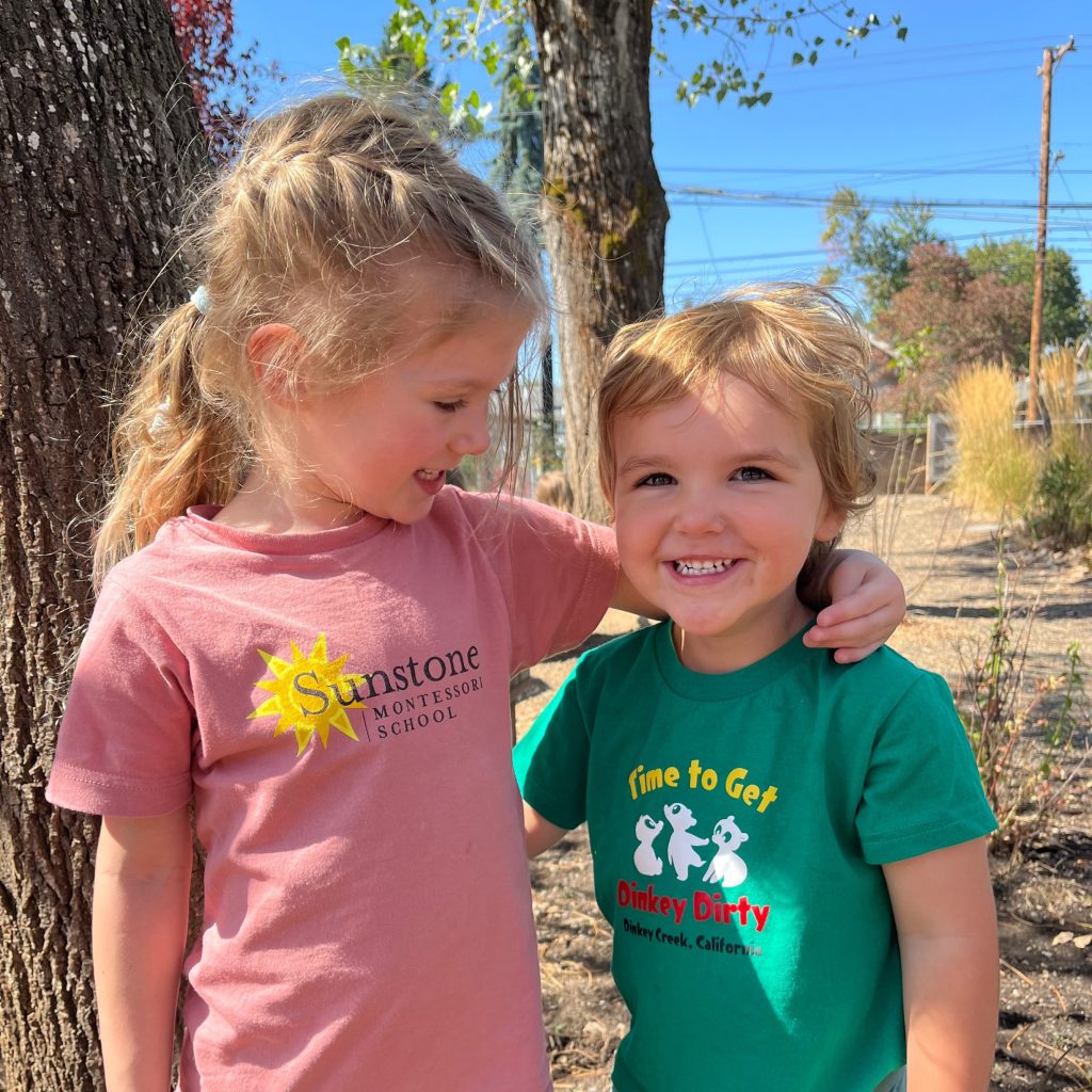 Two students show extreme care and kindness to each other on the playground knowing they belong to this community and feel safe